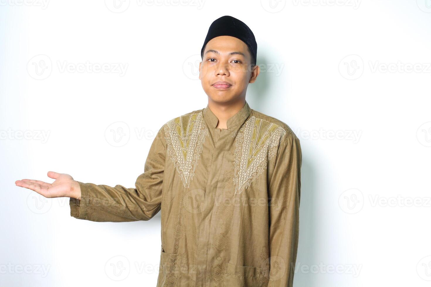 satisfeito ásia muçulmano homem vestindo Koko roupas apresentando para ao lado com aberto Palma isolado em branco fundo foto