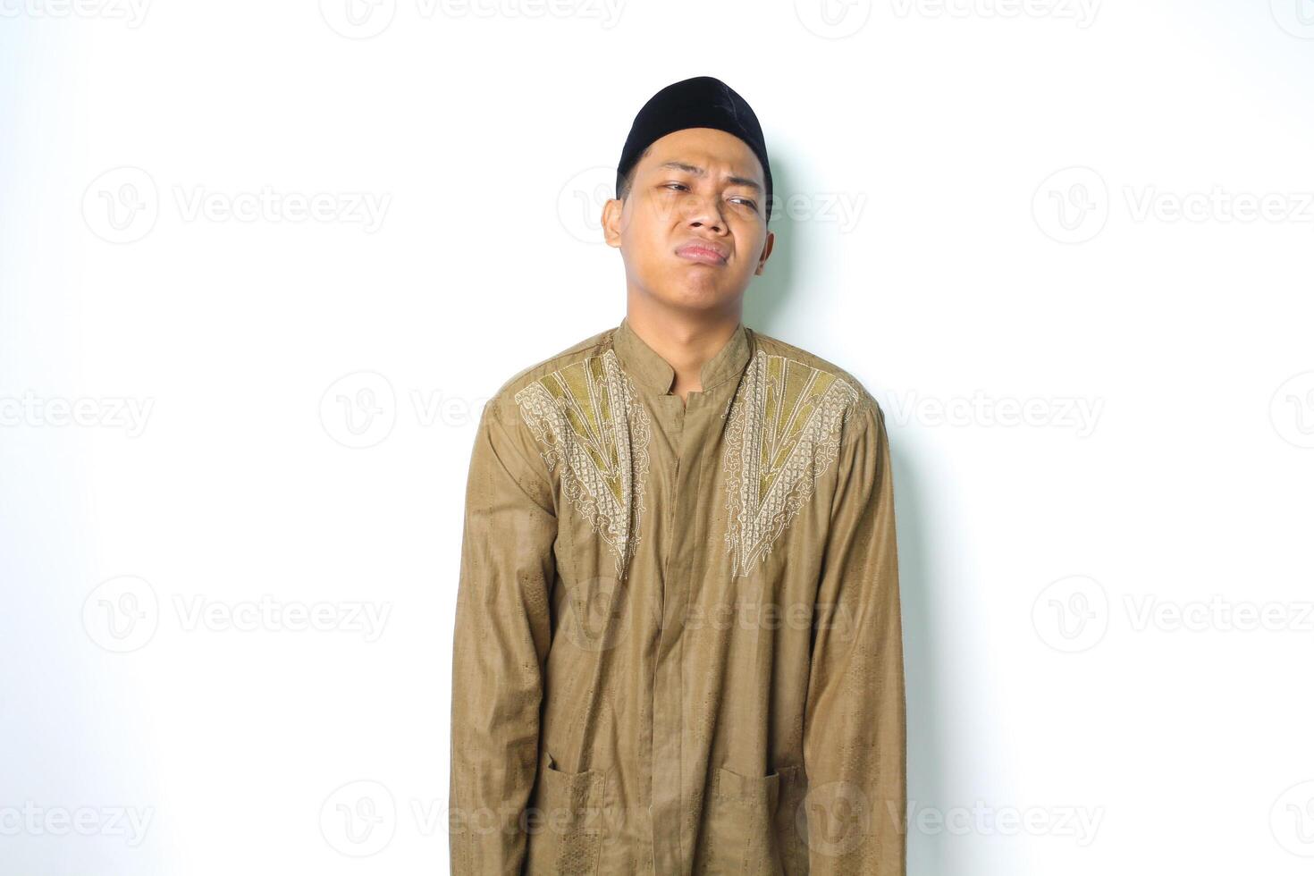 atraente ásia muçulmano homem vestindo islâmico roupas Veja depressivo isolado em branco fundo foto