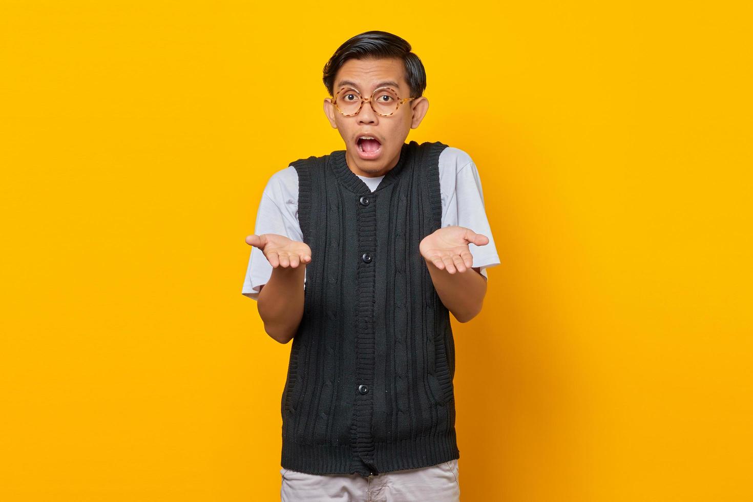 retrato de homem asiático surpreso com uma expressão de confusão e desagrado no fundo amarelo foto