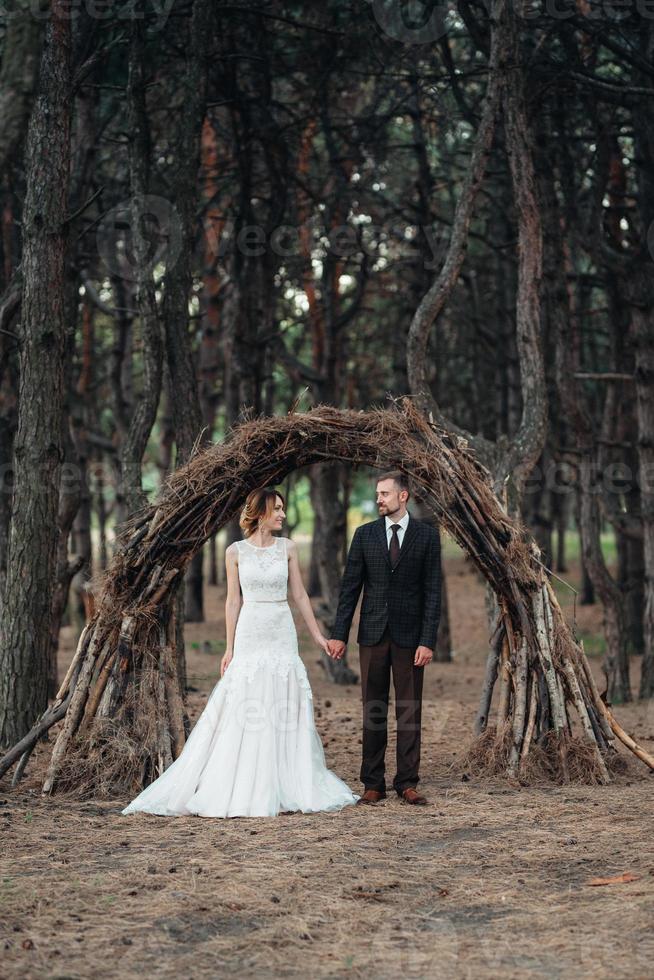 caminhada da noiva e do noivo pela floresta de outono foto