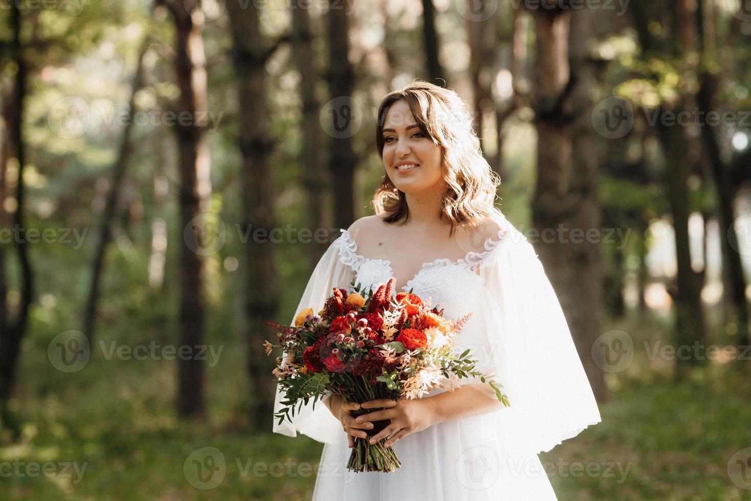 garota em um vestido de noiva na floresta de outono foto