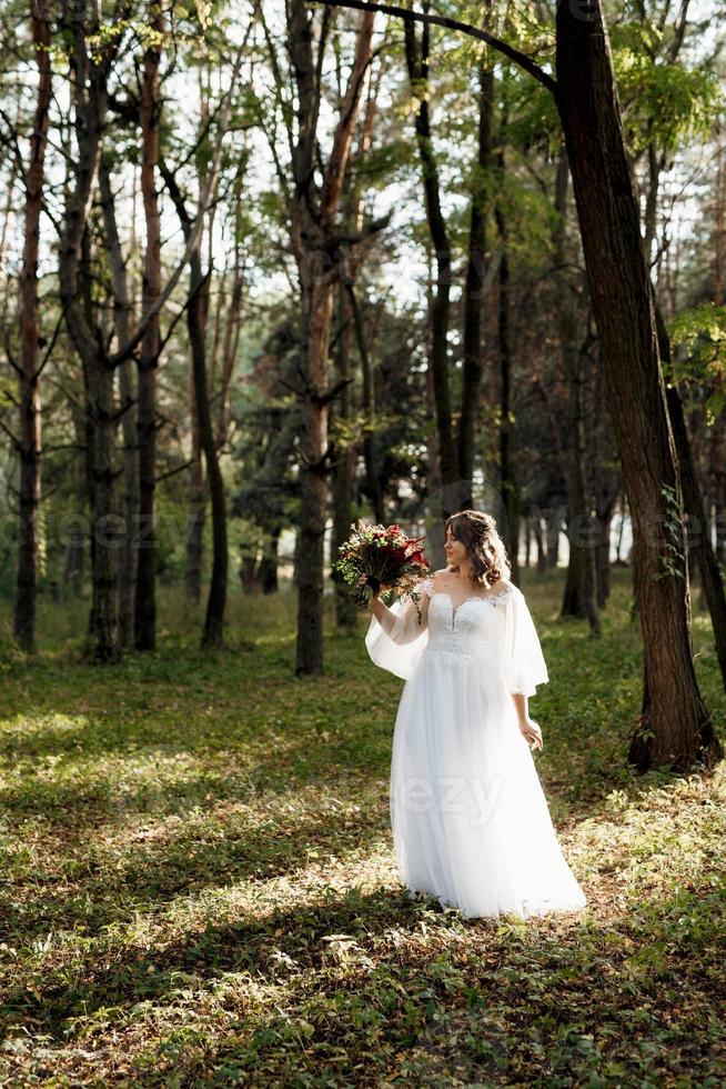 garota em um vestido de noiva na floresta de outono foto