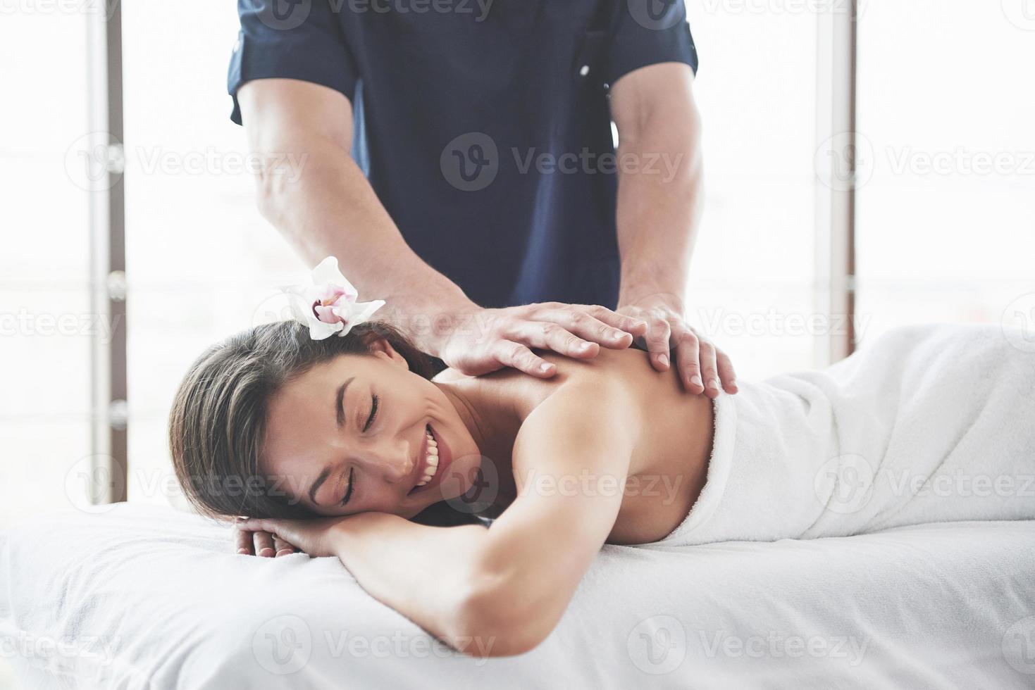 linda mulher deitada na mesa de massagem no spa. foto