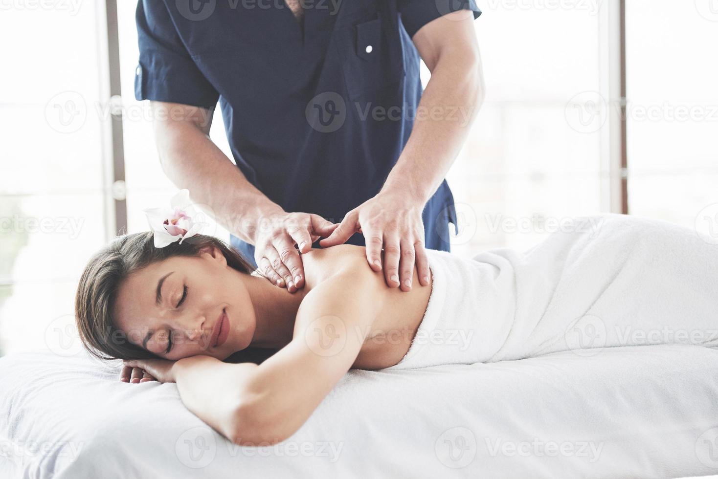 linda mulher deitada na mesa de massagem no spa. foto