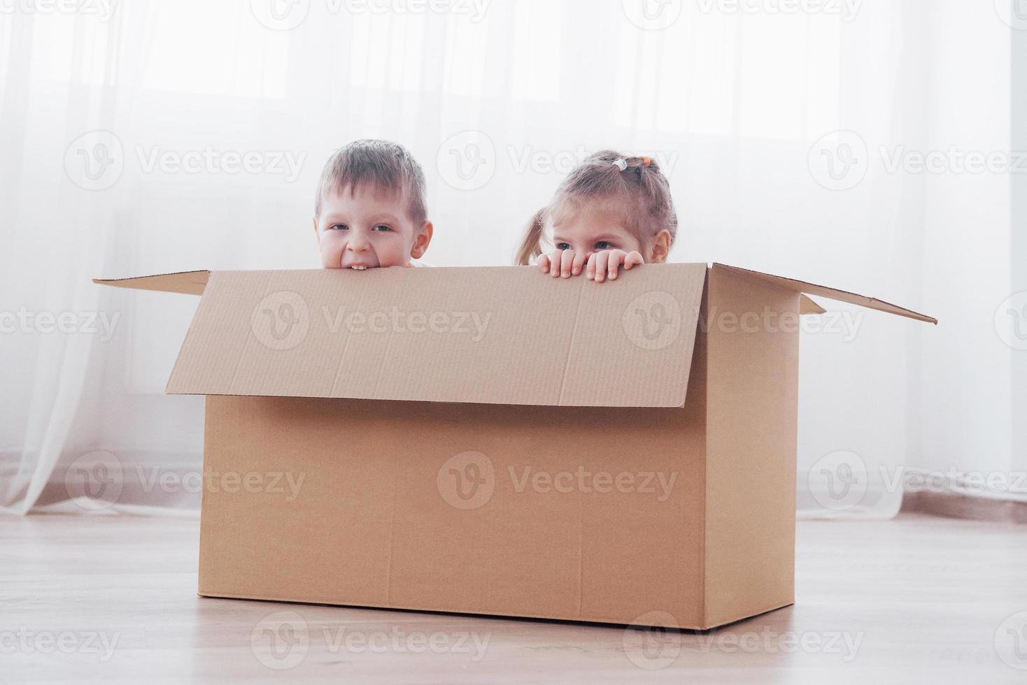 dois filhos, menino e menina, acabaram de se mudar para uma nova casa. foto do conceito ... as crianças se divertem.