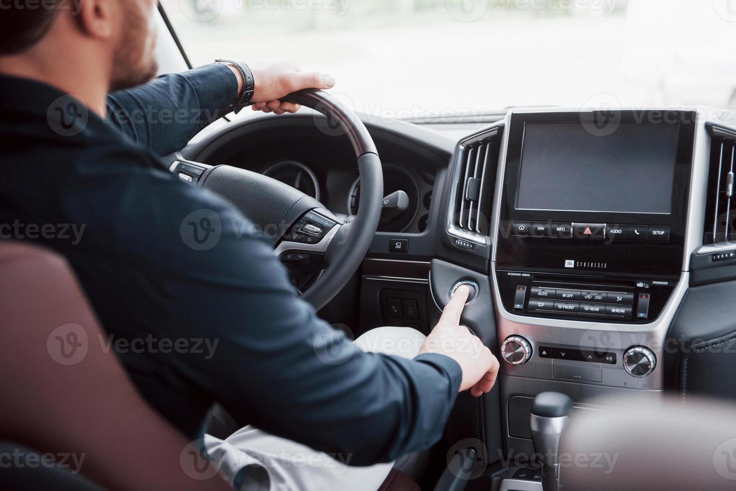 jovem empresário confiante sentado ao volante de seu novo carro foto