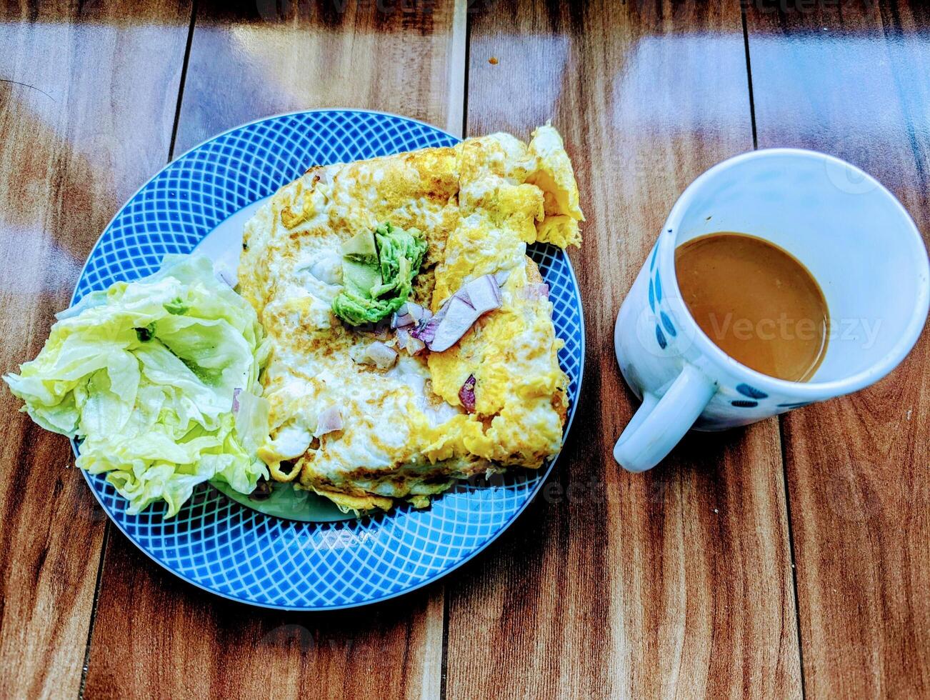 saudável café da manhã com pão torrada com ovo omelete alface e uma quente copo do leite chá. foto