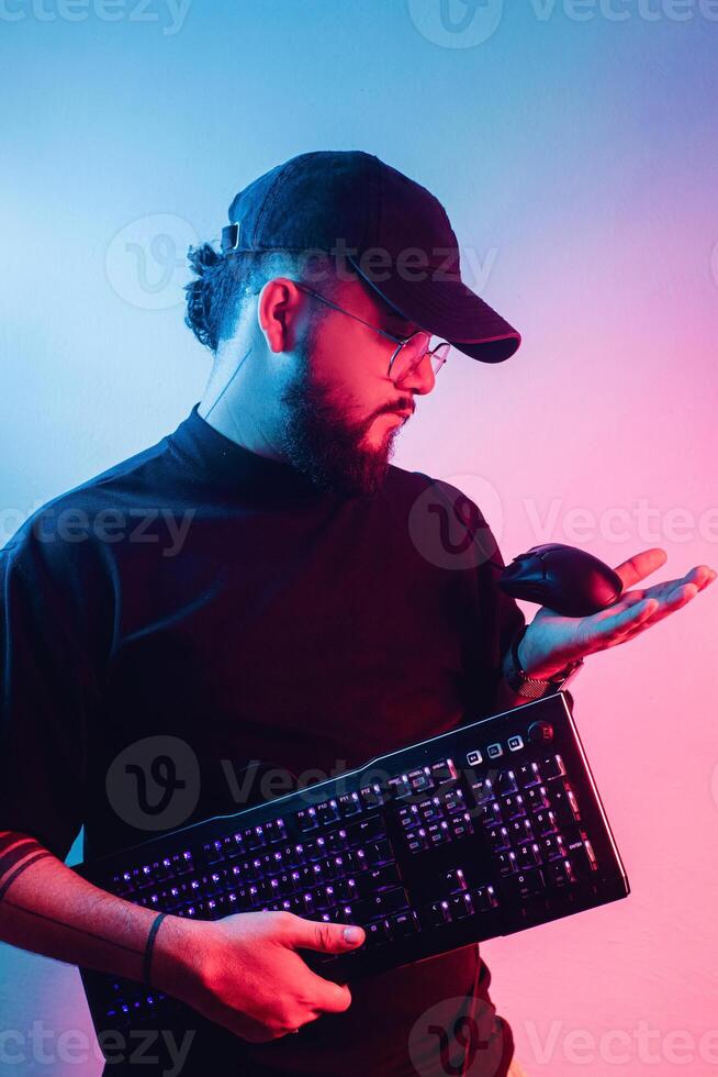 jovem latim americano homem com barba segurando uma jogos teclado e rato. foto