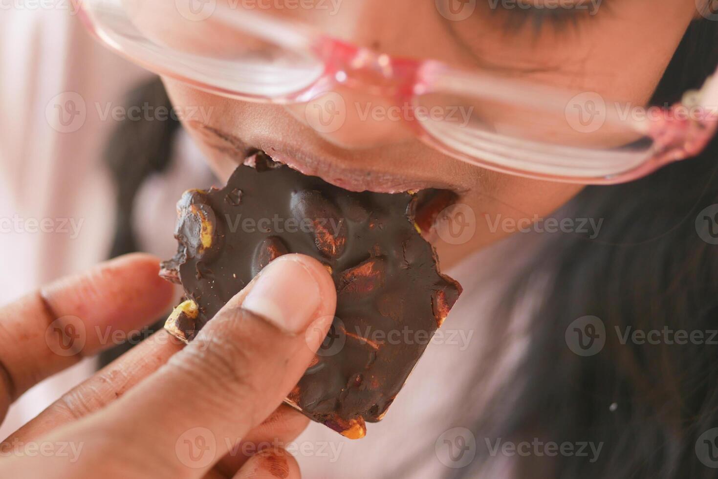 criança comendo Sombrio chocolate fechar acima foto