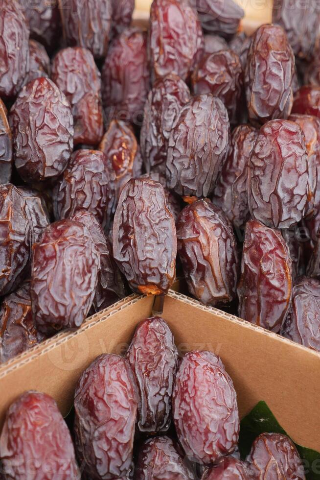 muitos expositores de frutas tâmaras à venda no mercado local foto