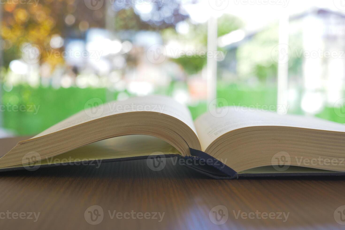 livro aberto e um lápis na mesa de madeira foto