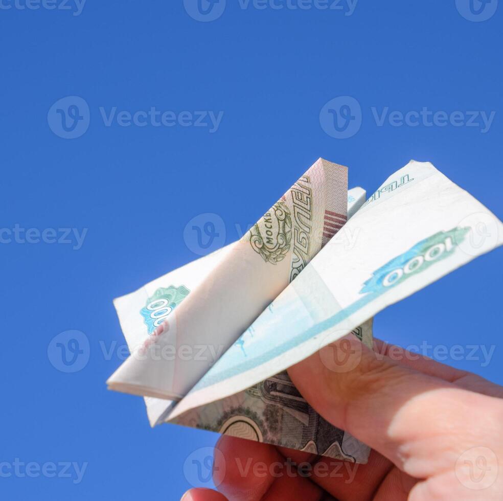 denominações do russo dinheiro, guardada dentro a avião contra a azul céu dentro mão foto