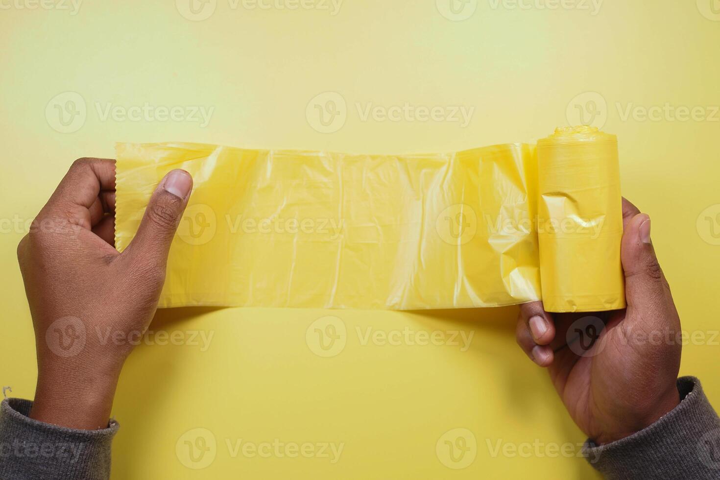 topo Visão do segurando uma amarelo cor Lixo bolsa. foto