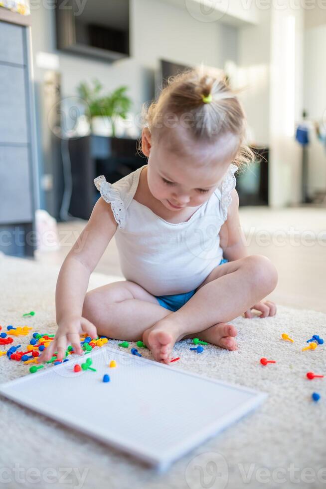 bonita pequeno menina jogando com cogumelo unha mosaico às lar. passatempo e lazer Tempo foto