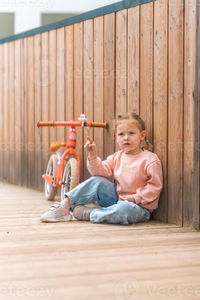 pequeno menina com Saldo bicicleta dentro a pátio do a residência dentro Praga, Europa foto
