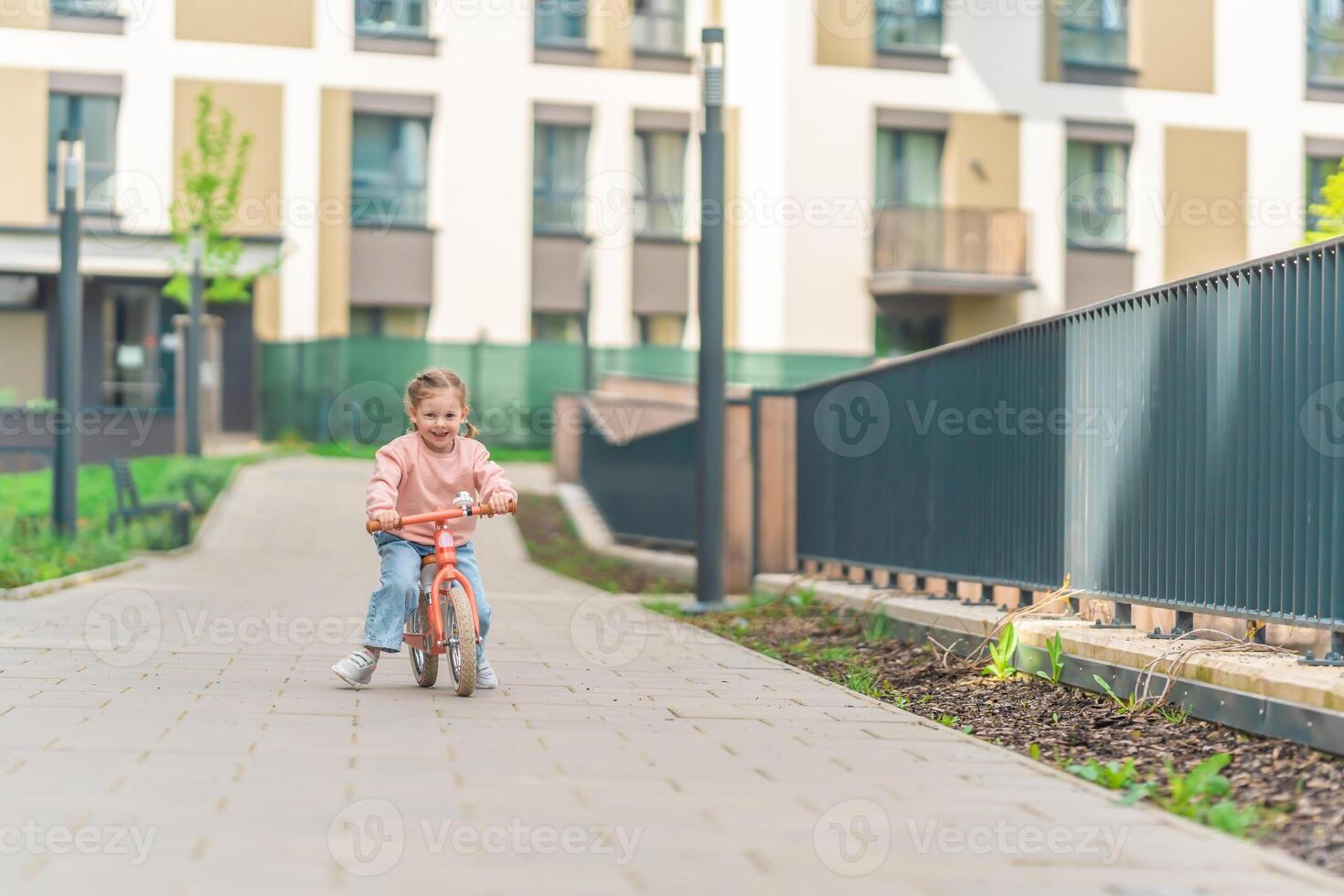 pequeno menina equitação Saldo bicicleta dentro a pátio do a residência dentro Praga, Europa foto