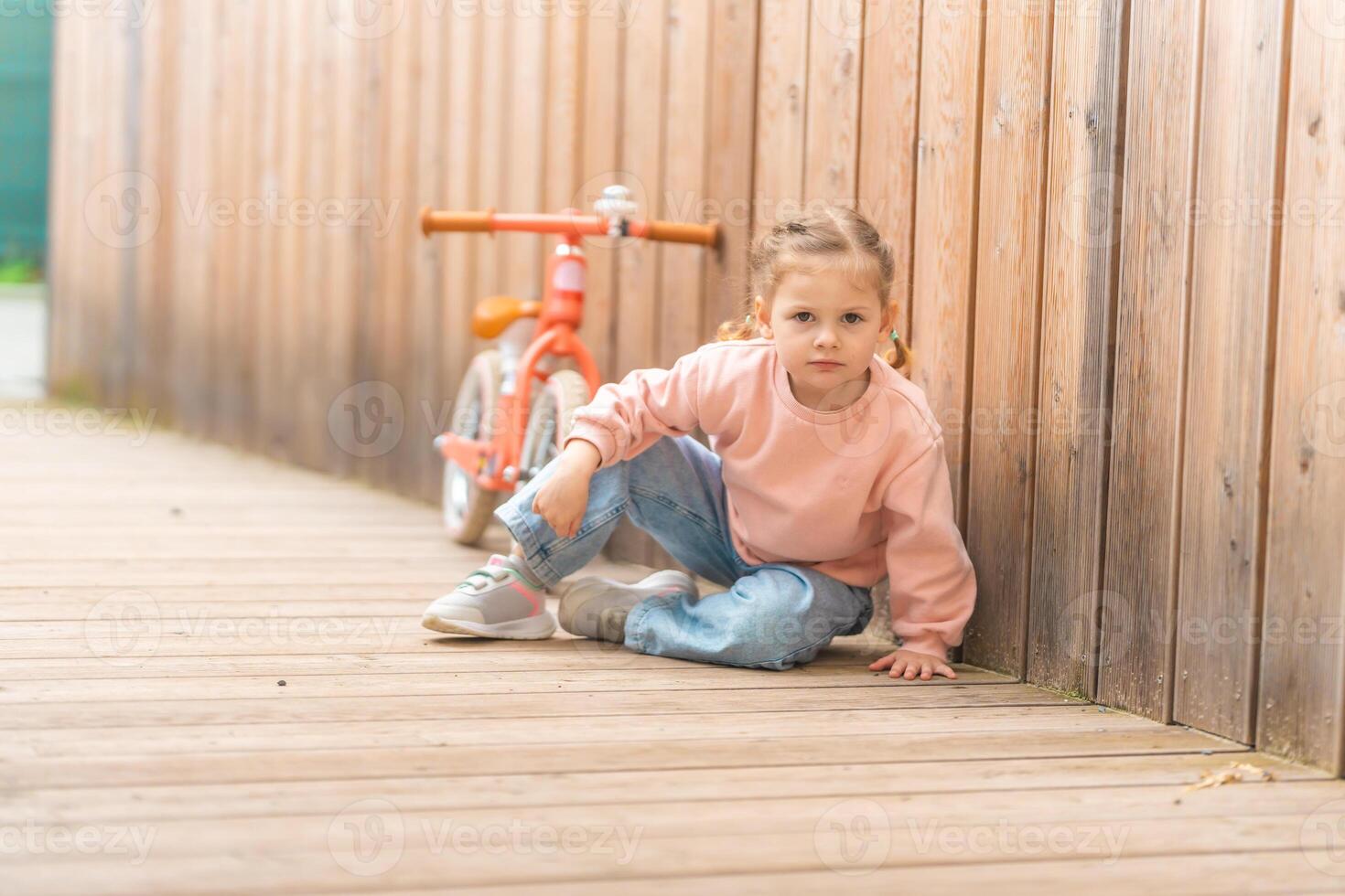 pequeno menina com Saldo bicicleta dentro a pátio do a residência dentro Praga, Europa foto