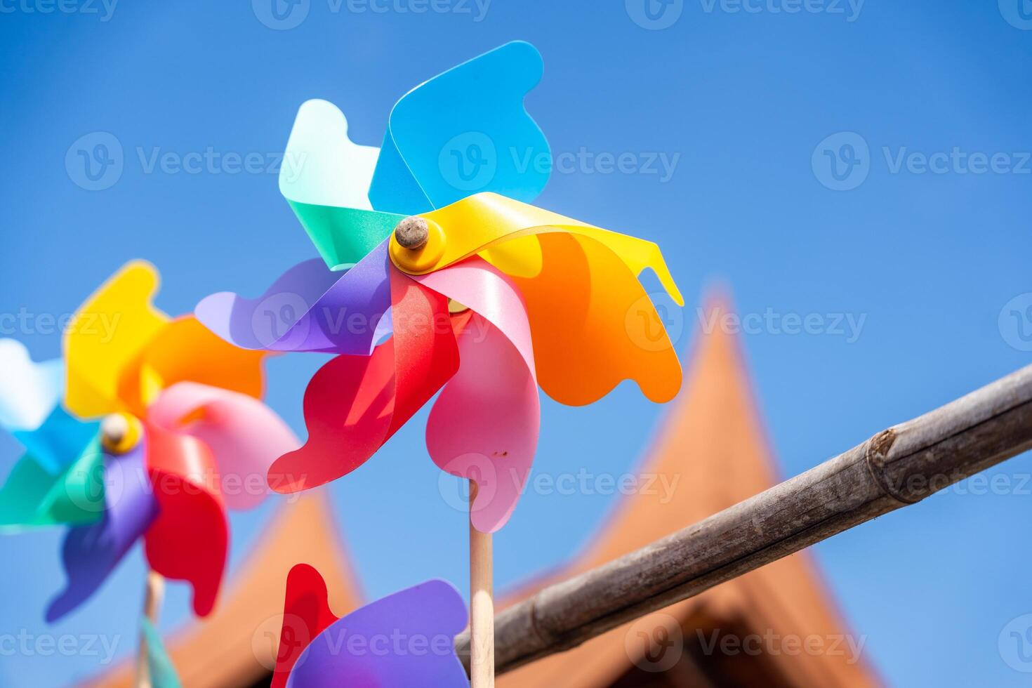 multicolorido moinho de vento brinquedos em azul céu fundo. Alto qualidade foto