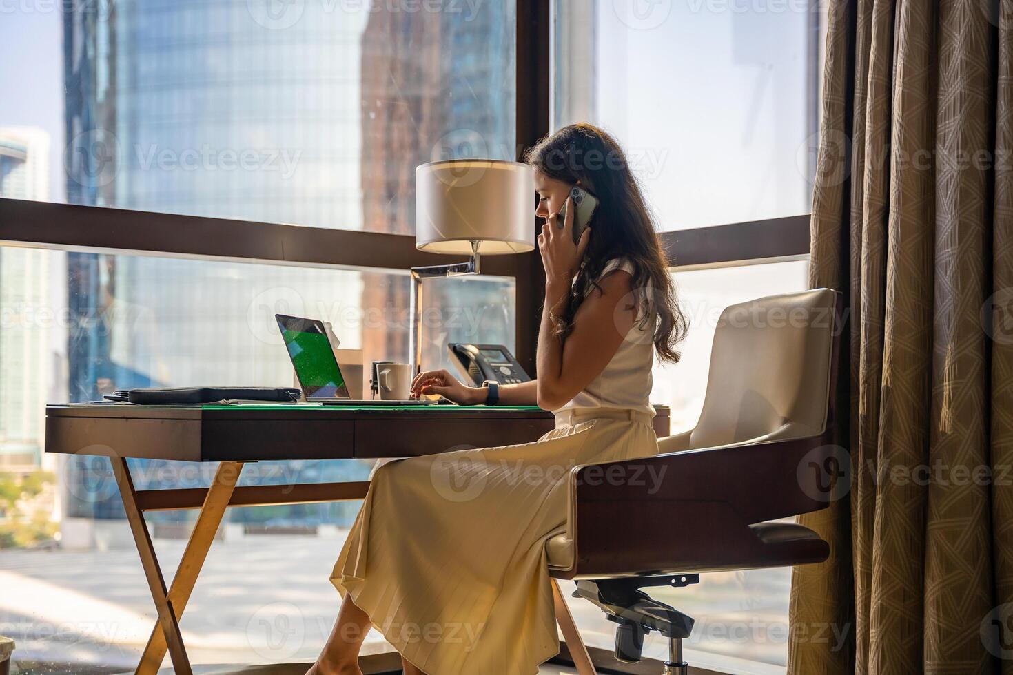 à moda empresária trabalhador autonomo trabalhando com computador portátil e Smartphone, ela é sentado em a cadeira, desfrutando panorâmico Visão dentro a cidade fundo. baixo chave foto. Alto qualidade foto