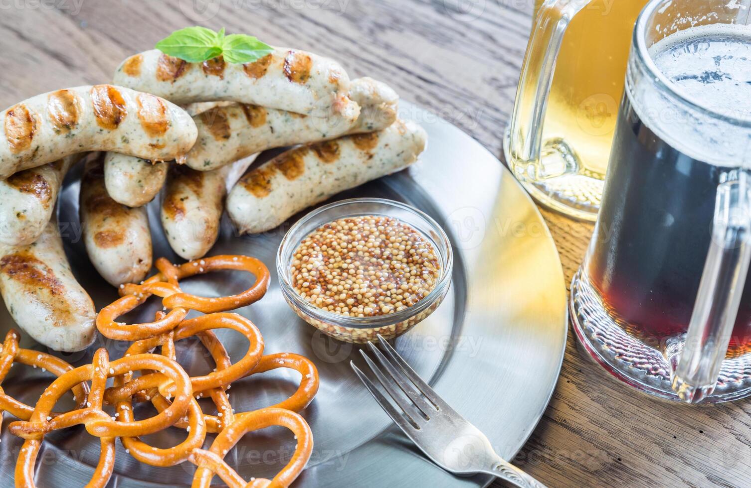 grelhado salsichas com salgadinhos e canecas do Cerveja foto