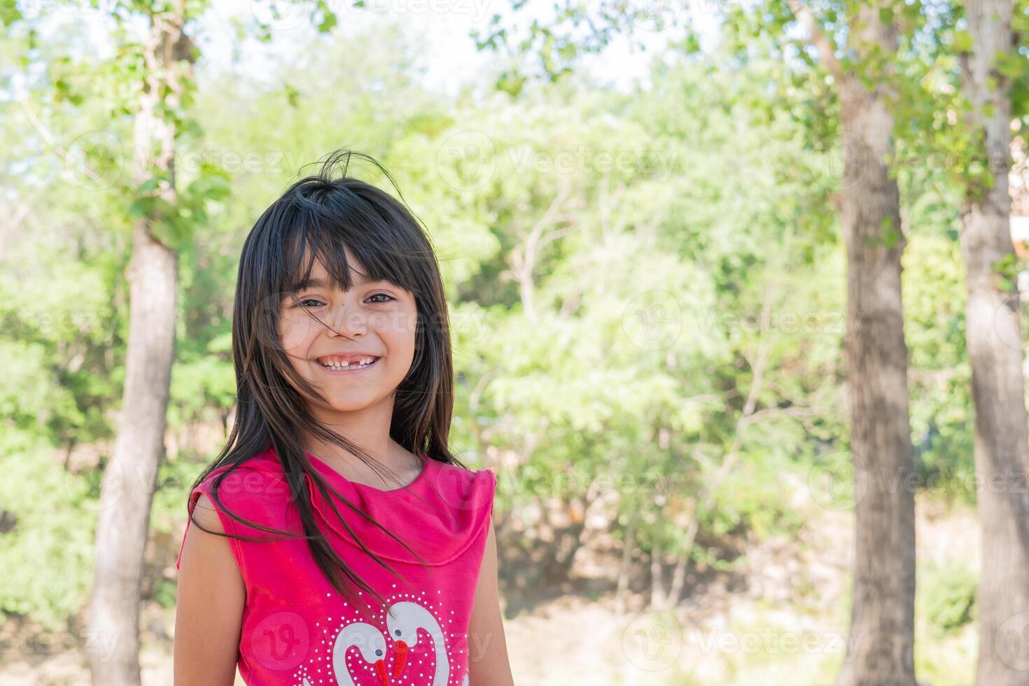 retrato do uma latim pequeno menina em uma lindo verde fundo. foto