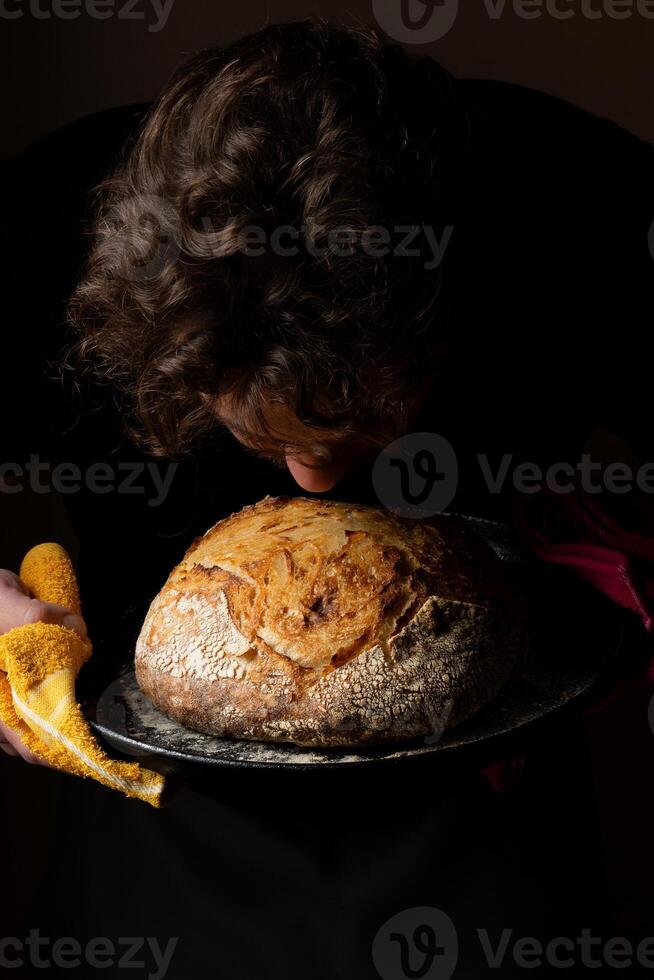 atraente jovem caucasiano chefe de cozinha posando com branco fermento pão. foto