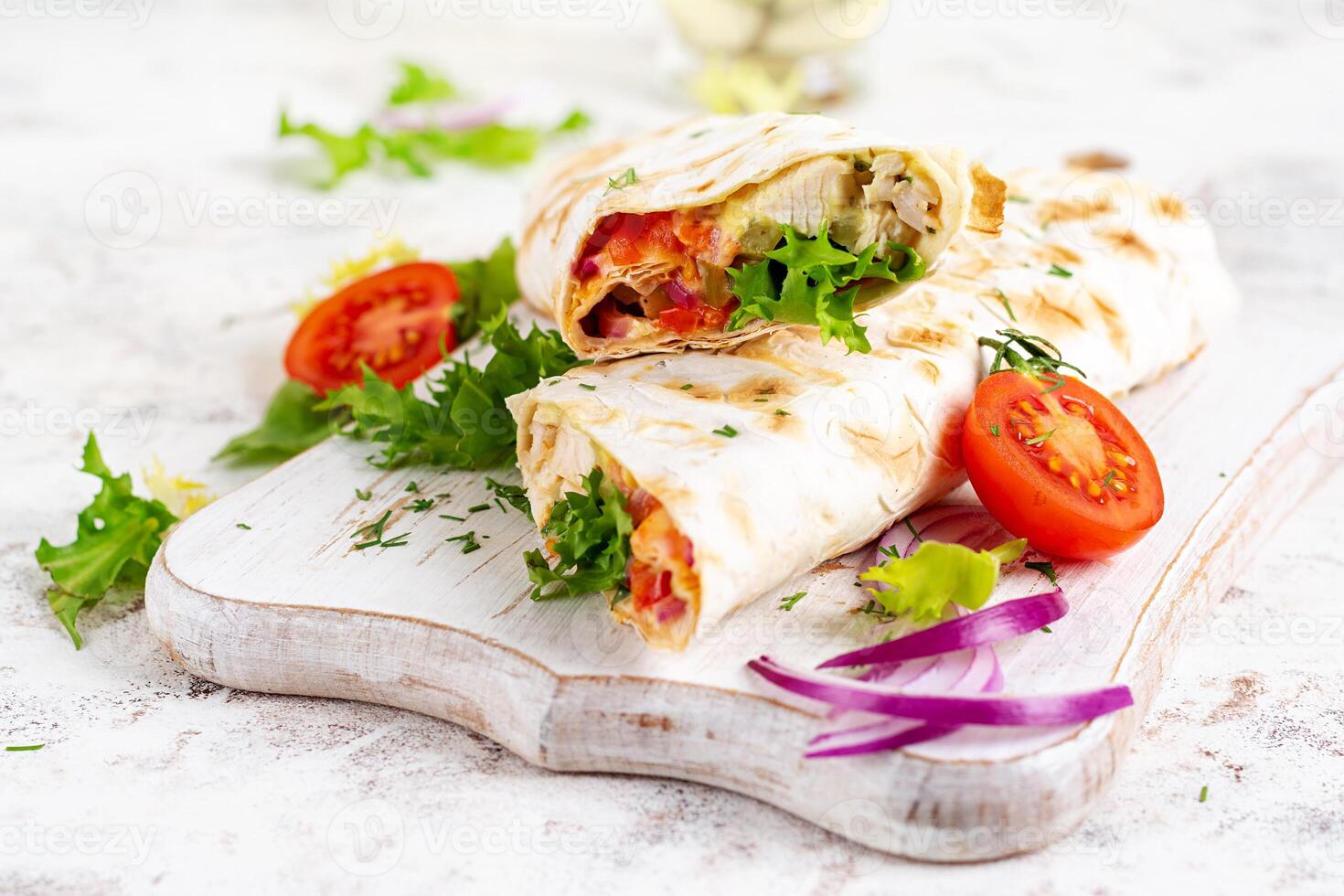 grelhado tortilla envoltórios com frango e fresco legumes em branco de madeira borda. frango burrito. mexicano Comida. saudável Comida conceito. foto