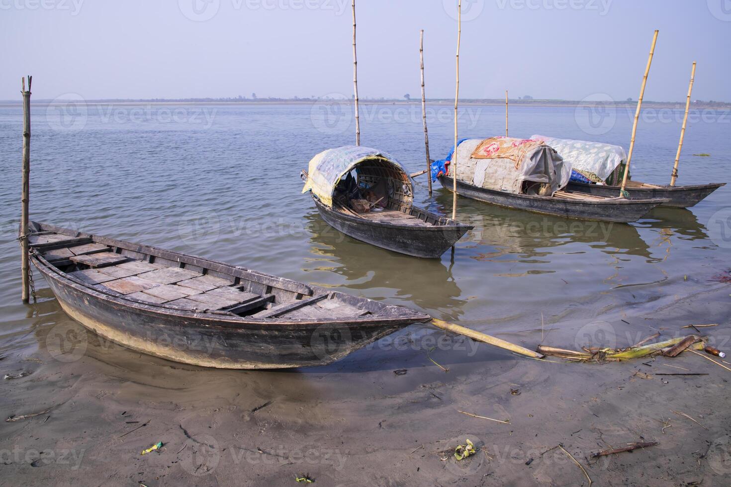 panorama Visão do alguns de madeira pescaria barcos em a costa do a Padma rio dentro Bangladesh foto