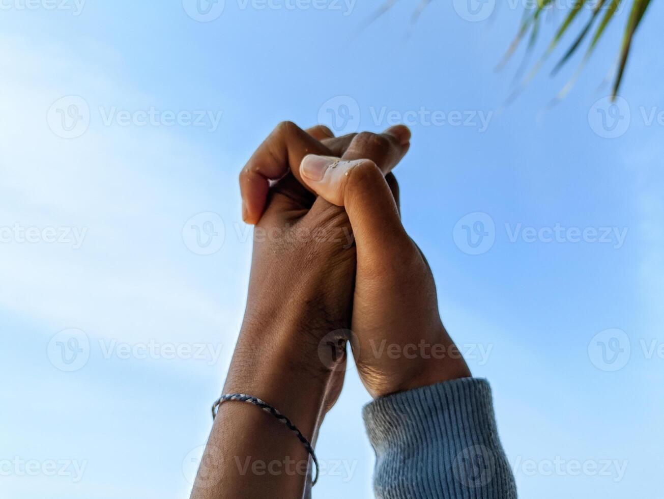 casal segurando mãos Como uma placa do afeição com a céu dentro a fundo foto