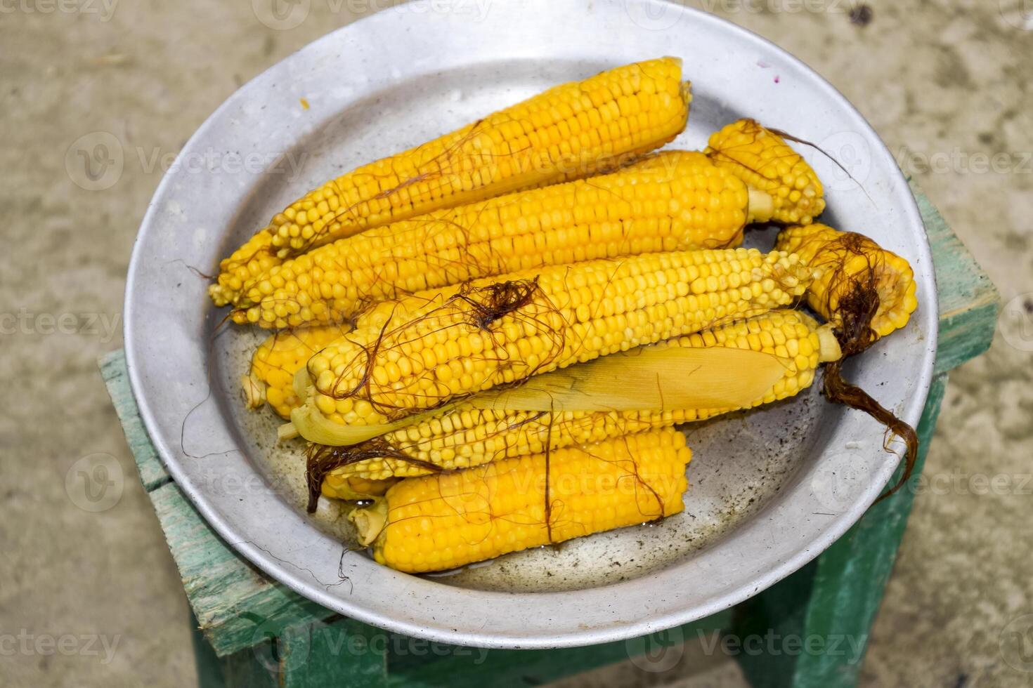 fervido milho em a alumínio bandeja. amarelo fervido jovem milho, útil e saboroso Comida foto