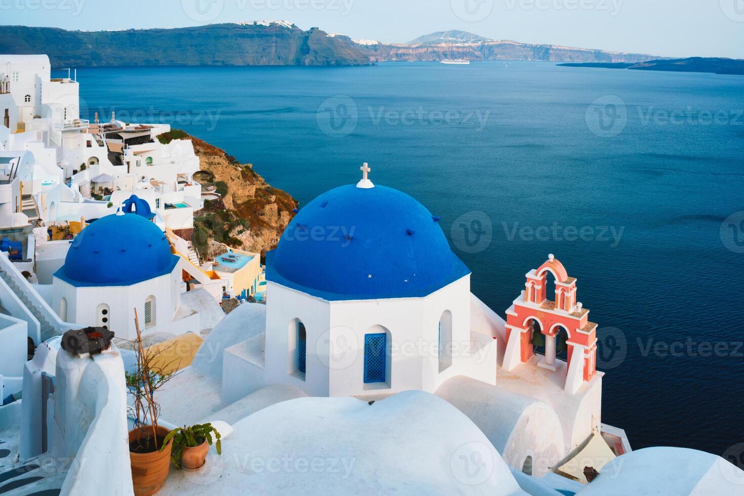 famoso Visão a partir de ponto de vista do santorini oia Vila com azul cúpula do grego ortodoxo cristão Igreja foto