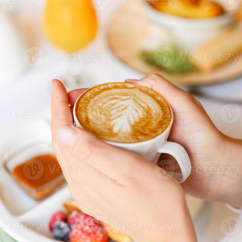mãos de folhas de café com leite foto