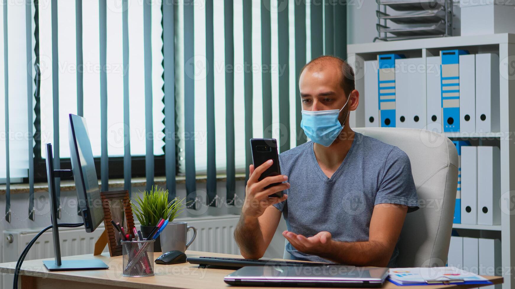 empregado com proteção face mascarar falando em Webcam com companhia líder sentado dentro moderno escritório. trabalhador autonomo trabalhando dentro Novo normal local de trabalho conversando tendo virtual conferência, encontro usando Internet foto