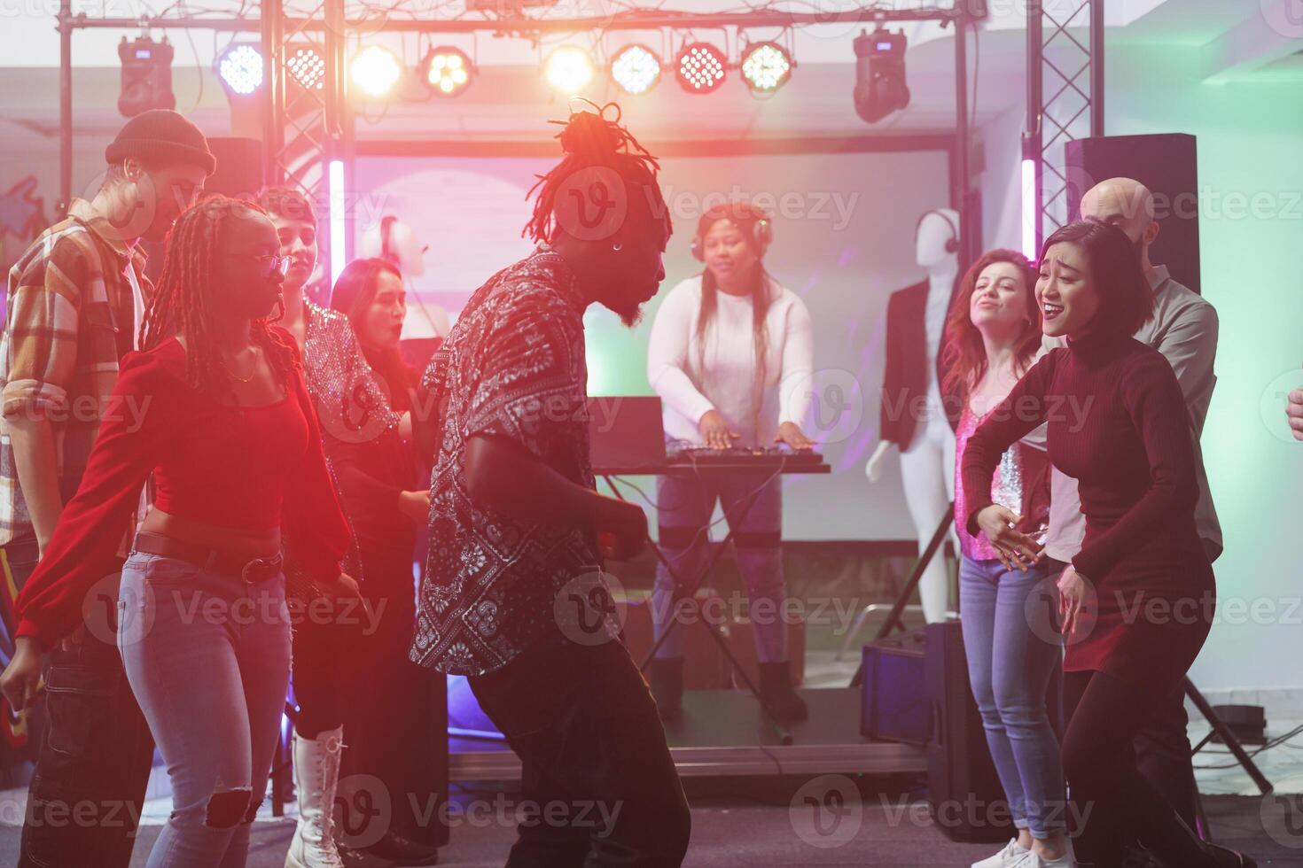 jovem homem e mulher mostrando movimentos às dança batalha enquanto festa dentro Boate. despreocupado alegre clubbers amigos tendo Diversão em lotado pista de dança às social encontro dentro clube foto