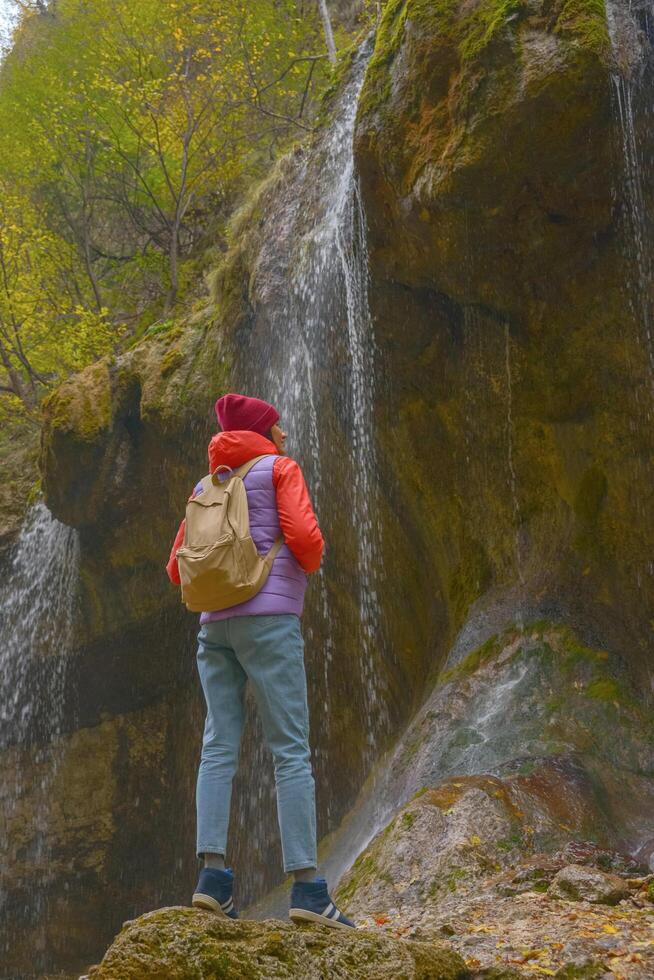 viagem. a menina viaja através a montanhas e cachoeiras do a selvagem. unidade, mental saúde, viagens ecológicas. caminhada, viajando, Boa vezes, digital desintoxicação. foto