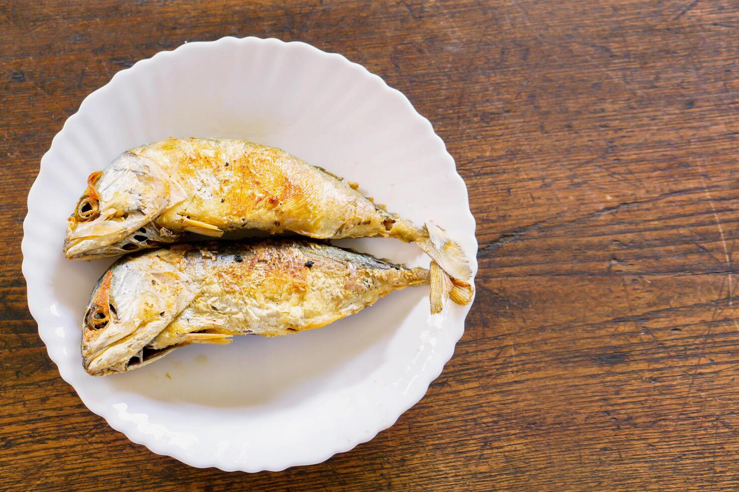 topo Visão frito cavalas em branco cerâmico prato e de madeira mesa com cópia de espaço fundo. frito cavalas popular para comer dentro Tailândia e comer com tailandês camarão colar Pimenta molho foto