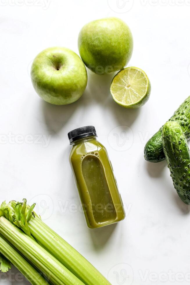 garrafa do verde batido com salsão e maçã em branco fundo foto