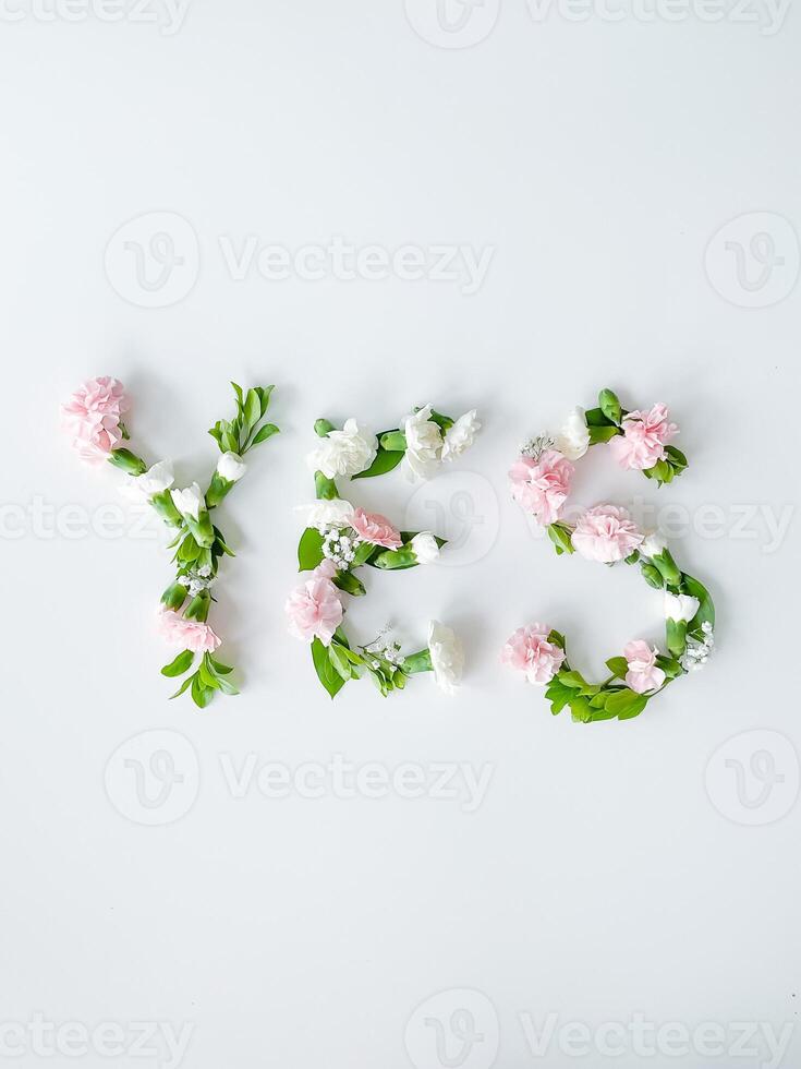 a palavra sim a partir de flores em uma branco fundo. foto