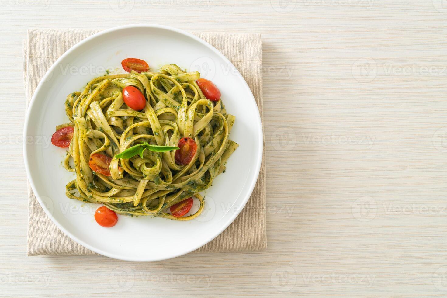 macarrão fettuccine espaguete com molho pesto e tomate foto