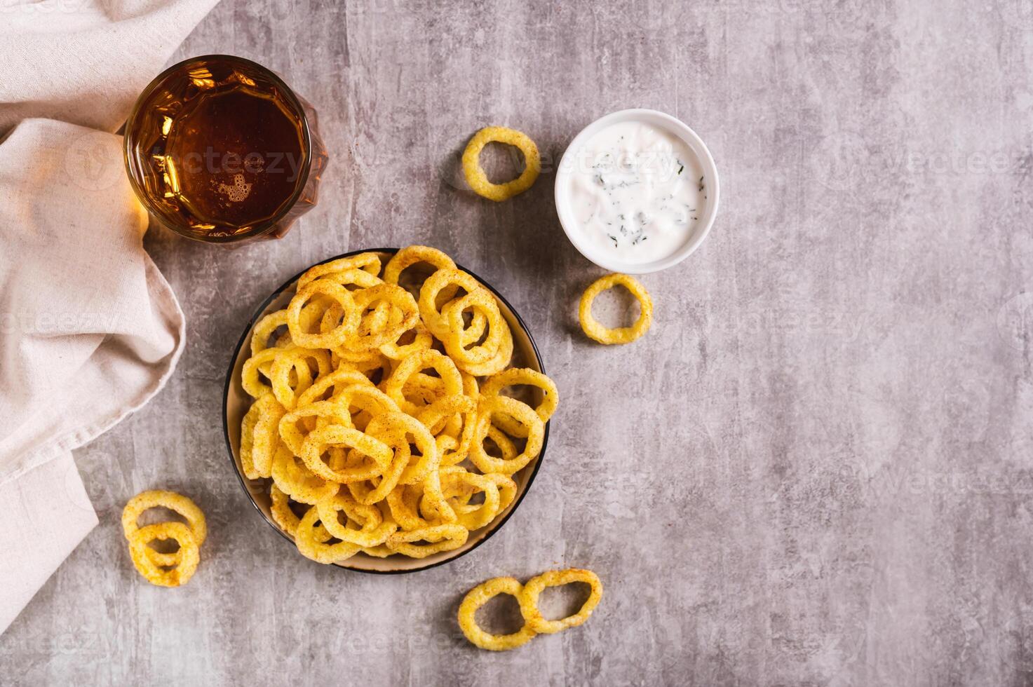 cebola argolas, molho e Cerveja dentro uma vidro em a mesa topo Visão foto