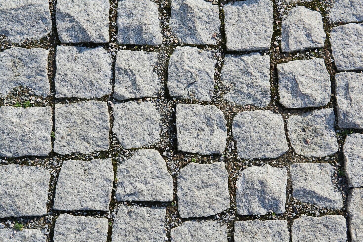 fundo - fragmento do a velho calçada pavimentou com granito pavimentação pedras foto