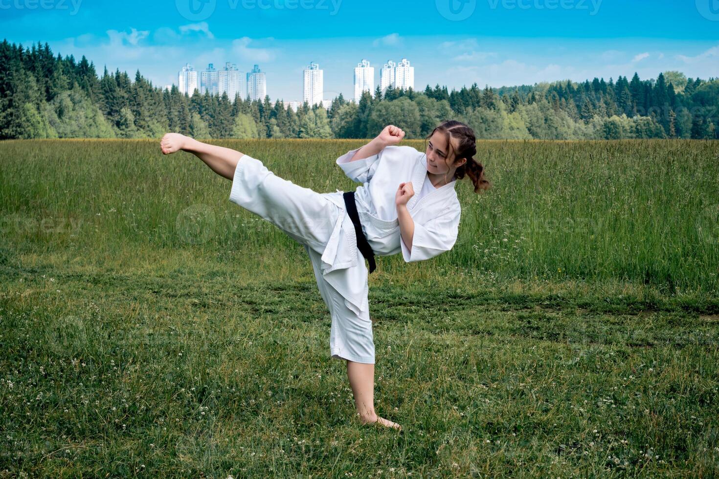 adolescente menina Treinamento karatê kata ao ar livre, executa a yoko geri pontapé foto