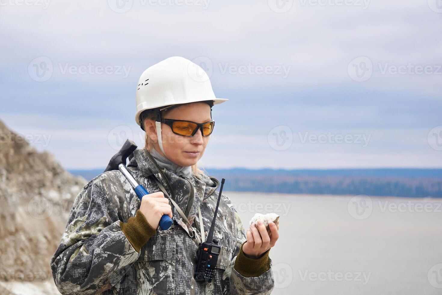 mulher geólogo examina uma mineral amostra às a Beira do a pedreira foto
