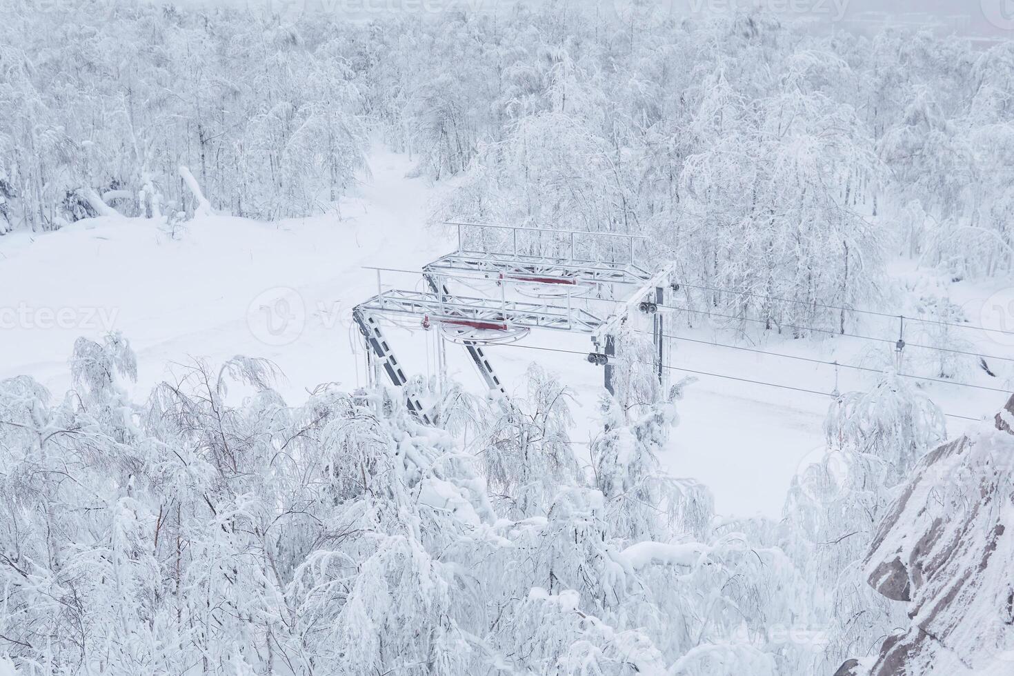 fim estação do a esqui lift em uma coberto de neve morro entre gelado árvores foto