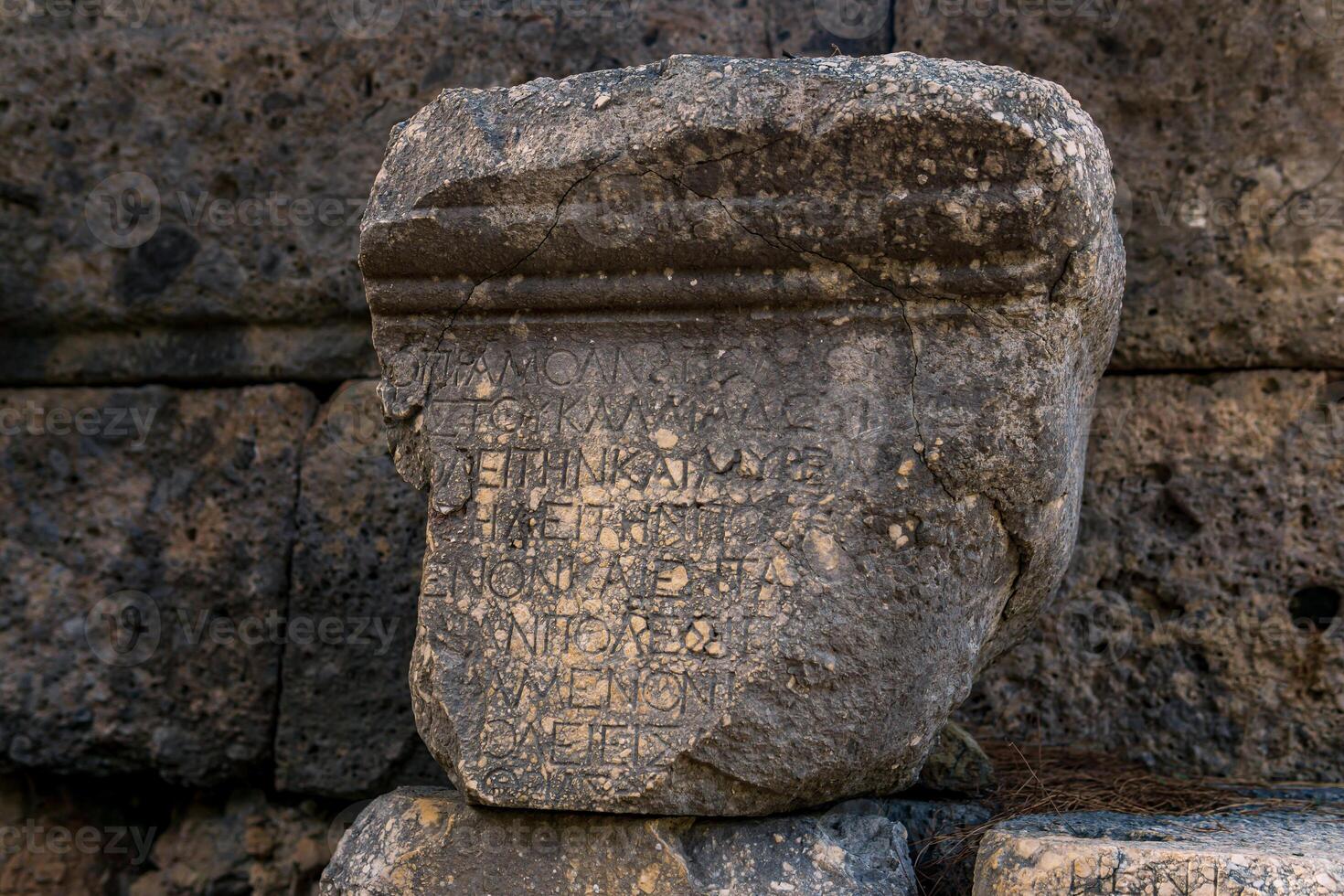 meio apagado Antiguidade inscrição em uma peça do pedra entre a ruínas do a antigo cidade do faselis, Peru foto