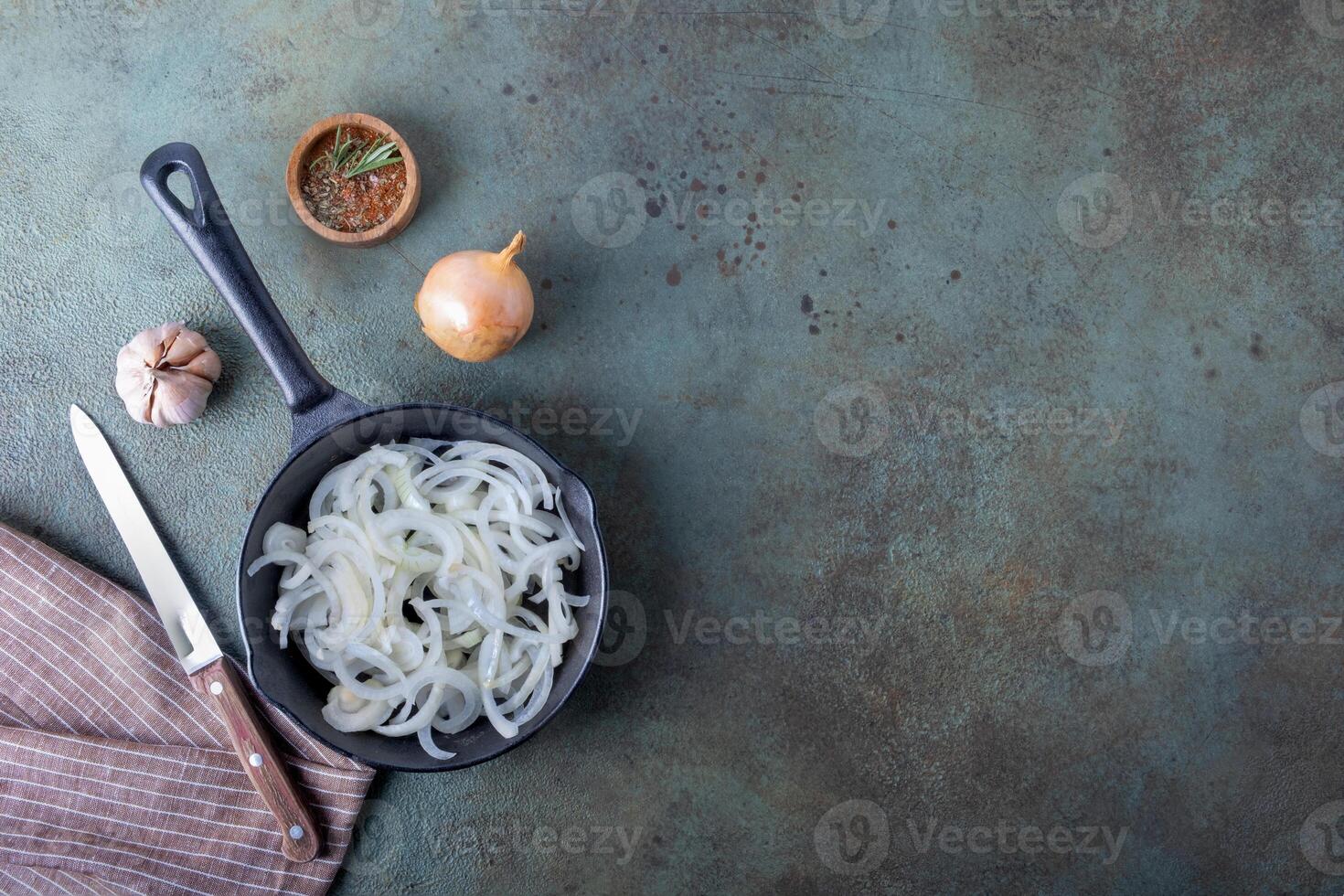 uma fritar panela com picado cebolas em pé em uma linho guardanapo em uma Sombrio superfície. foto