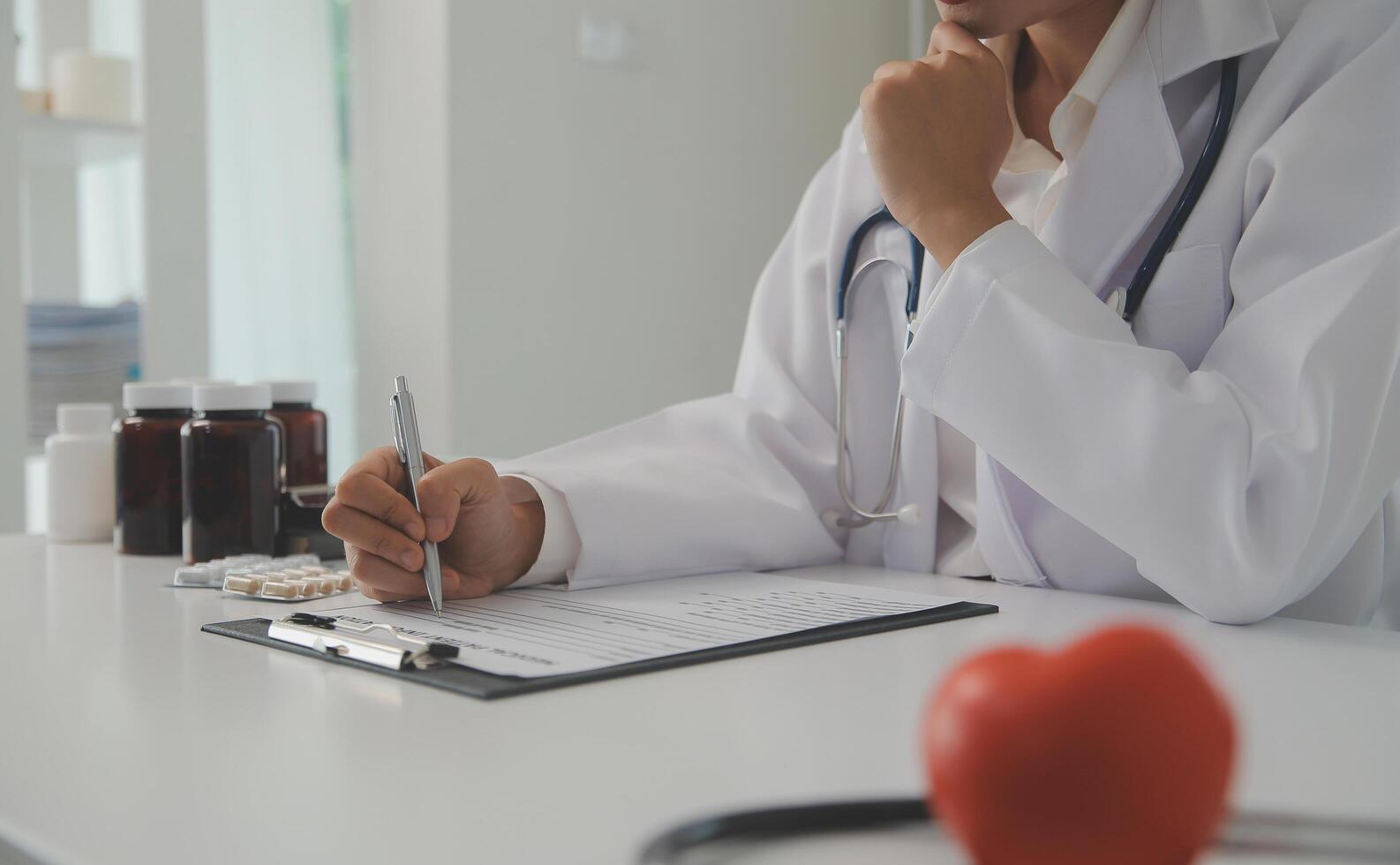 mãos do médico mulher segurando vermelho coração, mostrando símbolo do amor, humano Apoio, suporte para paciente, promovendo médico seguro, cedo checar para assistência médica, cardiologista ajuda. fechar acima do objeto foto