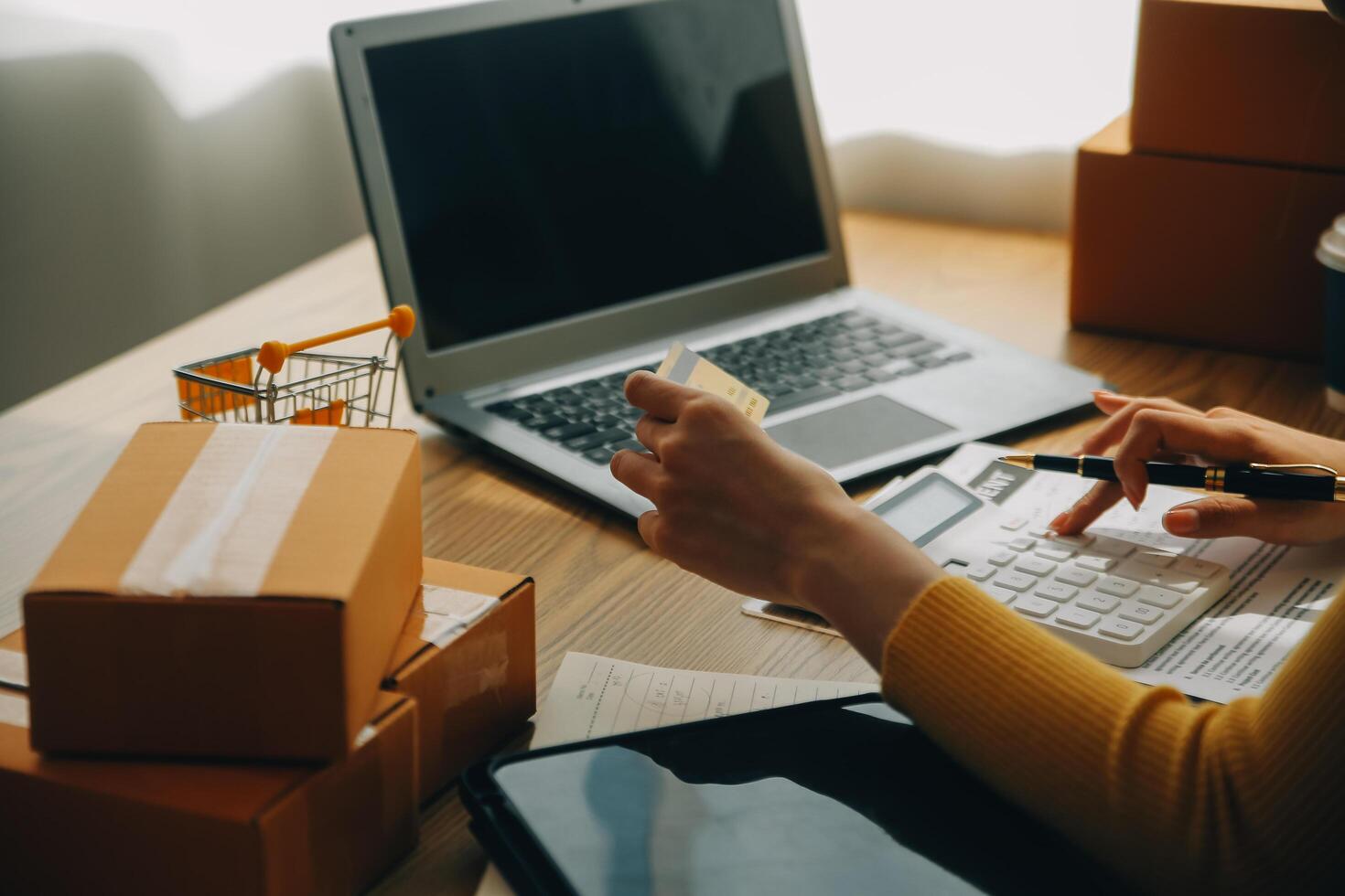 jovem mulher segurando uma Smartphone, tábua mostrando Forma de pagamento sucesso e crédito cartão com amarelo parcela caixa Como conectados compras conceito dentro escritório foto