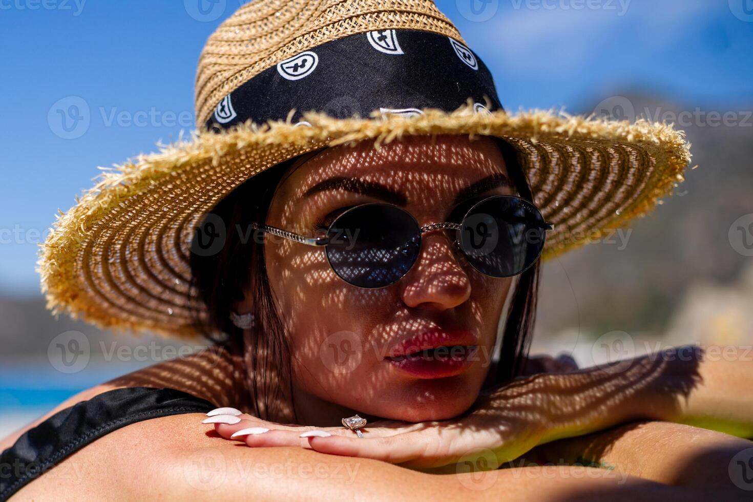 mulher dentro bikini e Palha chapéu deitado em tropical de praia foto