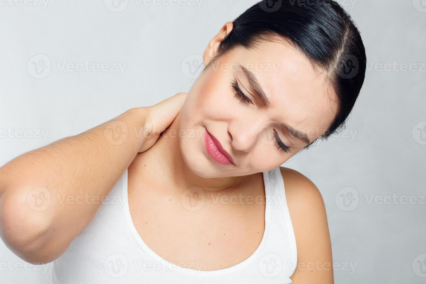 cansado pescoço. lindo jovem mulher sofrimento a partir de pescoço dor foto